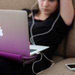 Photo of woman sitting on couch with laptop